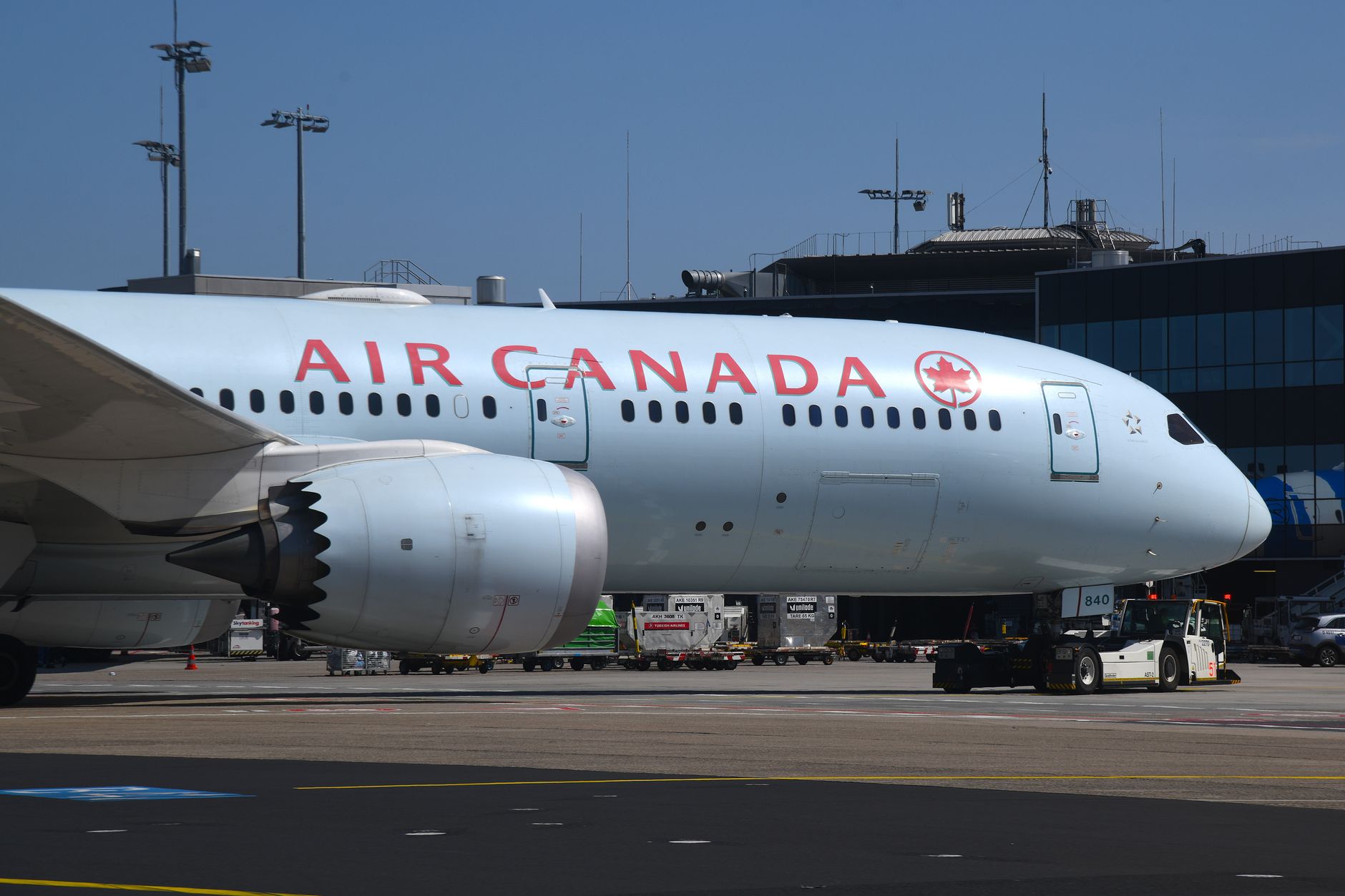 An Air Canada widebody jet parked at an airport terminal